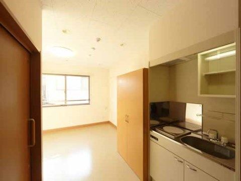 居室は広めの間取りになっている。トイレやミニキッチン、収納家具が備わっている。窓が設けられており、日中は明るい日差しが差しこんでくる。