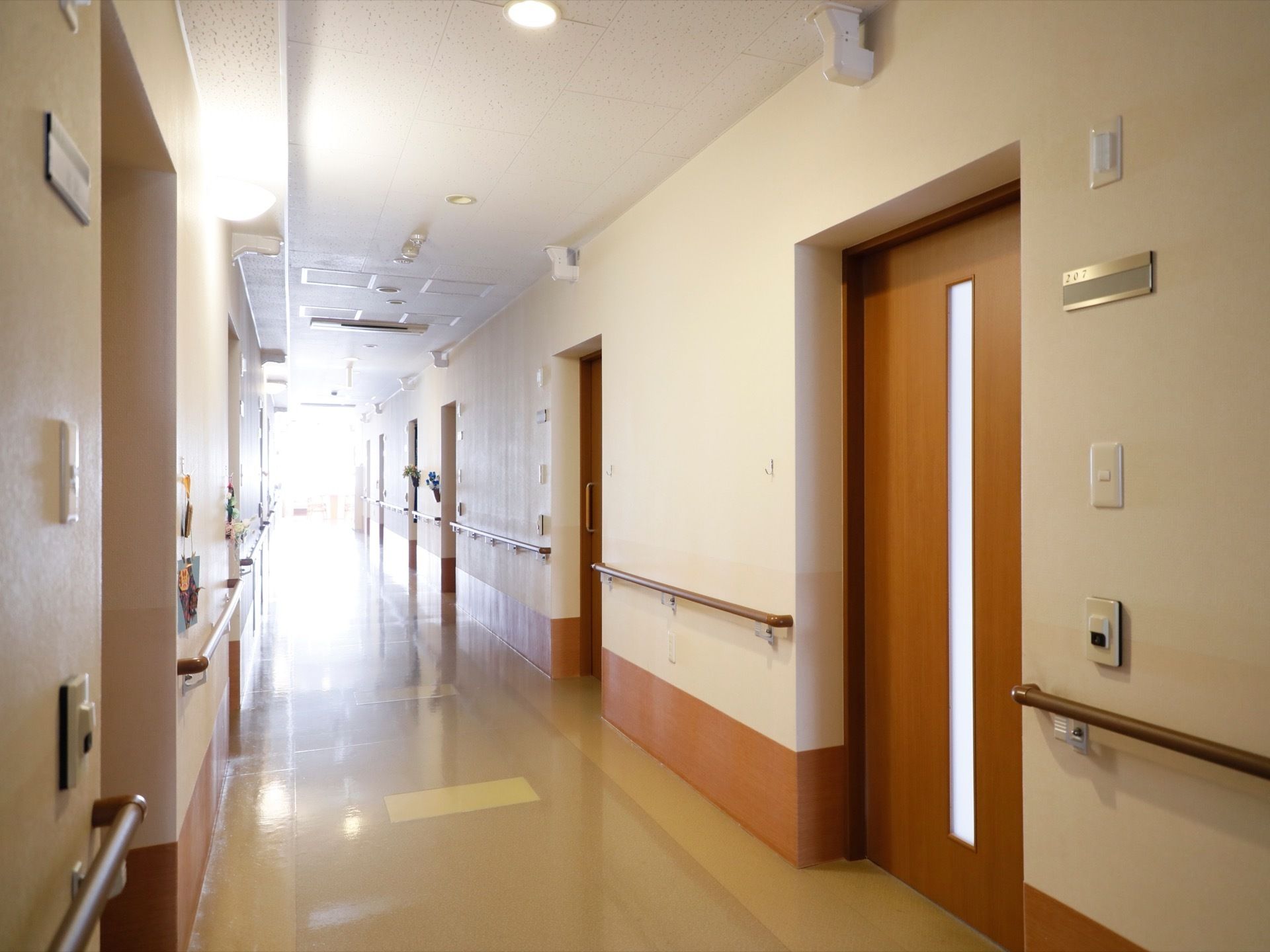 居室扉の側には、チャイムボタンや部屋番号が書かれた表札が設置されている。入居者様は思いおもいに扉を飾っている。