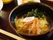 チャーシュー、わかめ、なるとがのっている美味しそうなラーメン画像。その他、ライス、副菜もついたボリュームのある食事。