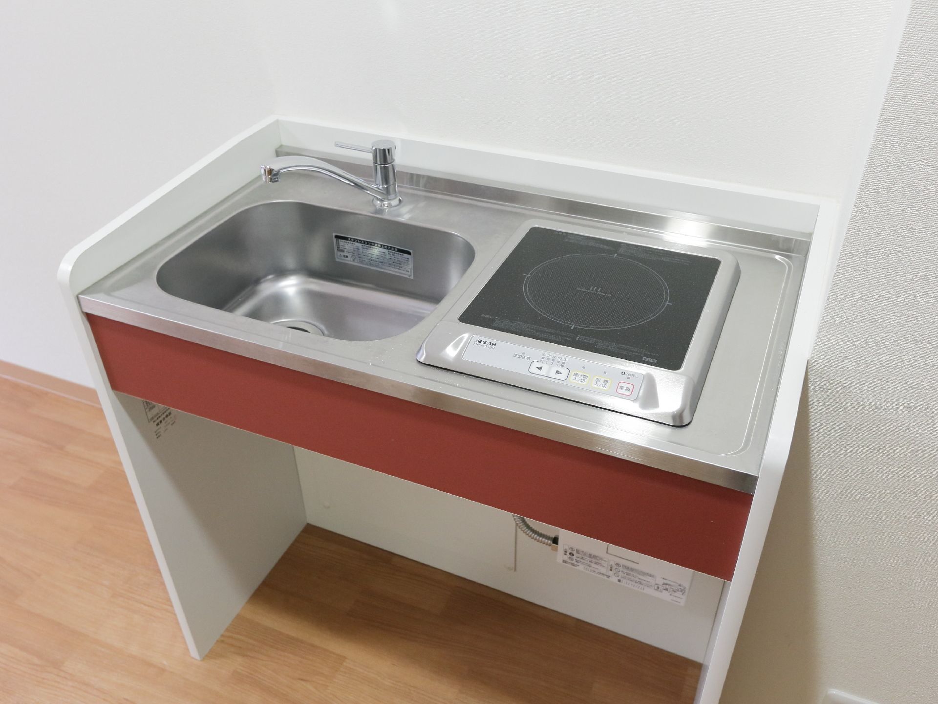 居室内に設置されている、コンパクトなキッチンシンク。使いやすい蛇口が付いたシンクと電磁調理器が取り付けらえれているので