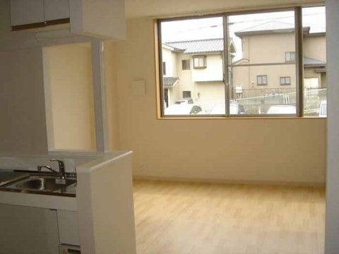 左手前にオープンキッチンがあり、奥が居住スペースになっている居室