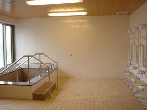 窓が大きく、ベージュの天井と床が明るい浴室である。４人ほど入れる大きな浴槽には、手すりを使って入浴する。