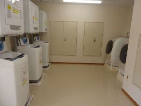ドラム式洗濯機が２台と、乾燥機と別になった縦型洗濯機が３セット、ゆとりを持って置いてある。広くて明るく清潔感がある。