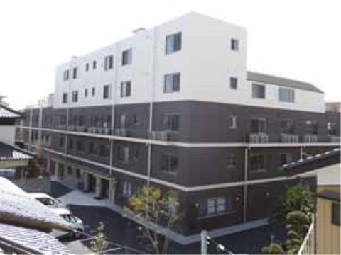 周囲を住宅地に囲まれている、５階建ての茶色と白の建物