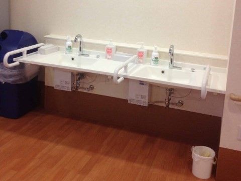 手すりが洗い場の両側に設置されている、２台並んだ洗面台