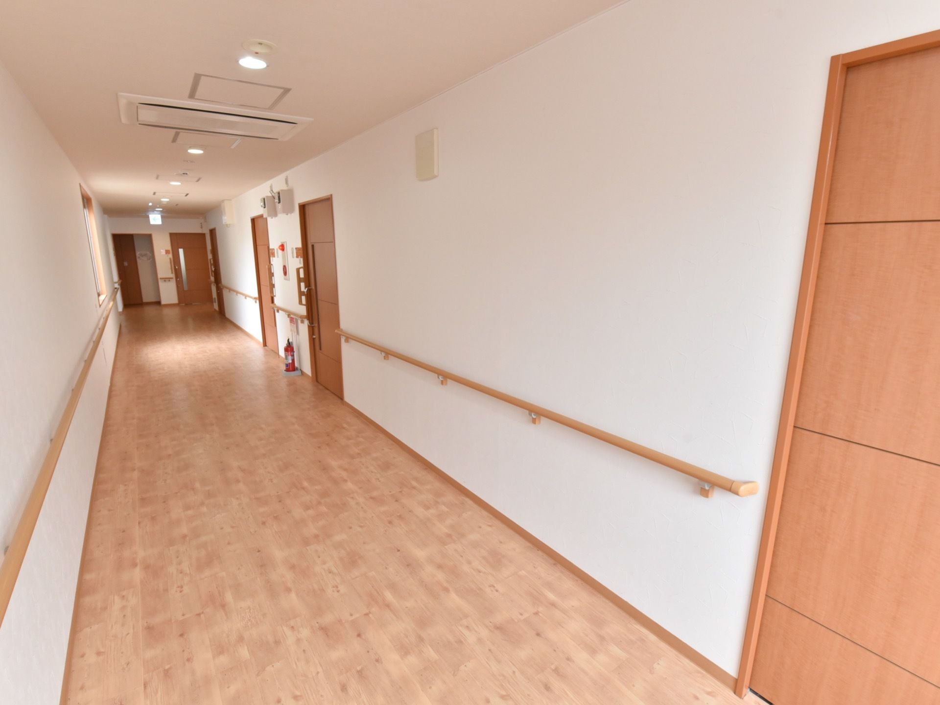 通路には広々とした幅を確保し、床は端まで段差なく整えている。緊急時に備えて非常用押しボタンと消火器を完備。