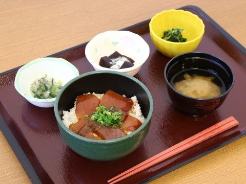 まぐろ漬け丼、味噌汁、小鉢2品、コーヒーゼリーの食事内容。色とりどりのお皿を使用し、大きさも多種類である。