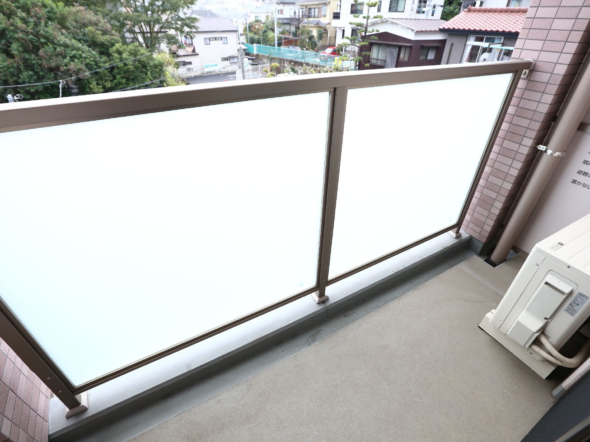 ベランダからは、住宅などの街並みが見える。隣室と仕切りがあるが、非常時は破って避難するようになっている。