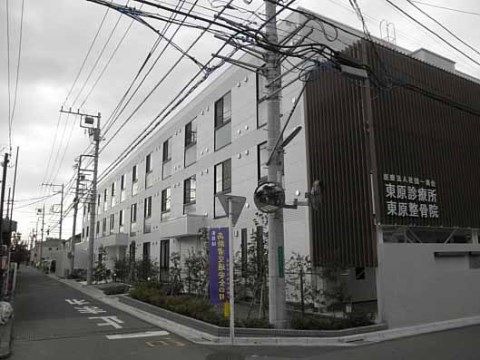 壁に診療所や整骨院の表示がされている茶色い施設建物