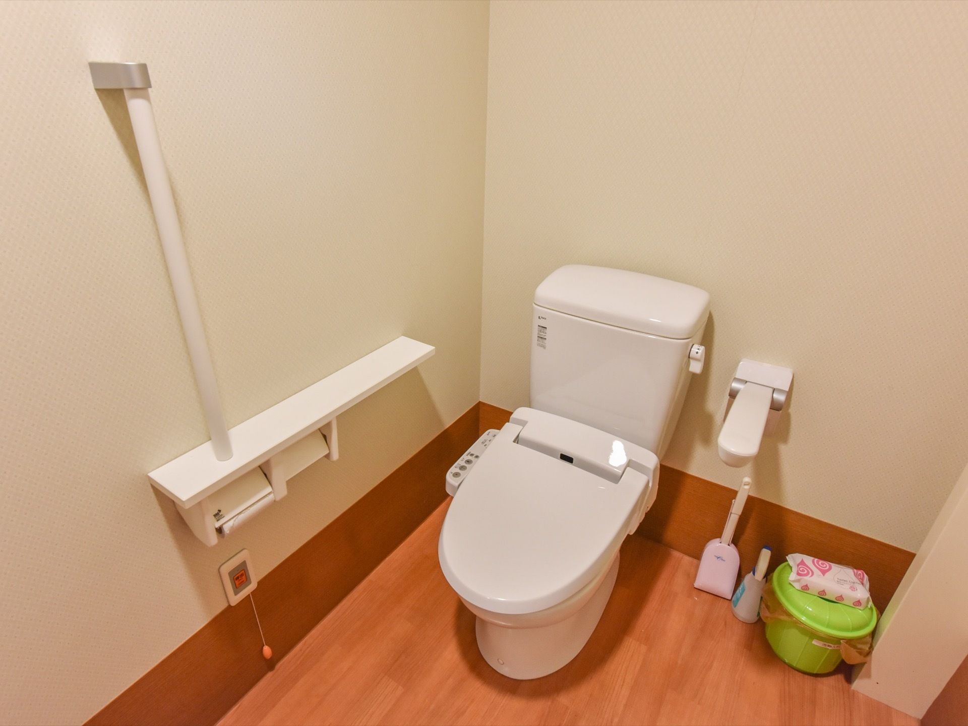 トイレは洋式である。いつでも清掃できるよう、洗剤など掃除道具が準備されている。便器の両側に手すりがある。