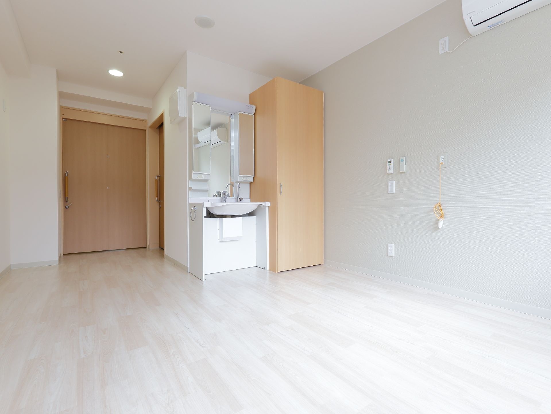 白色で清潔感がある部屋に、クローゼットと洗面化粧台が設置されている。部屋のドアは引き戸で幅があるので車いすでの出入りがしやすい。