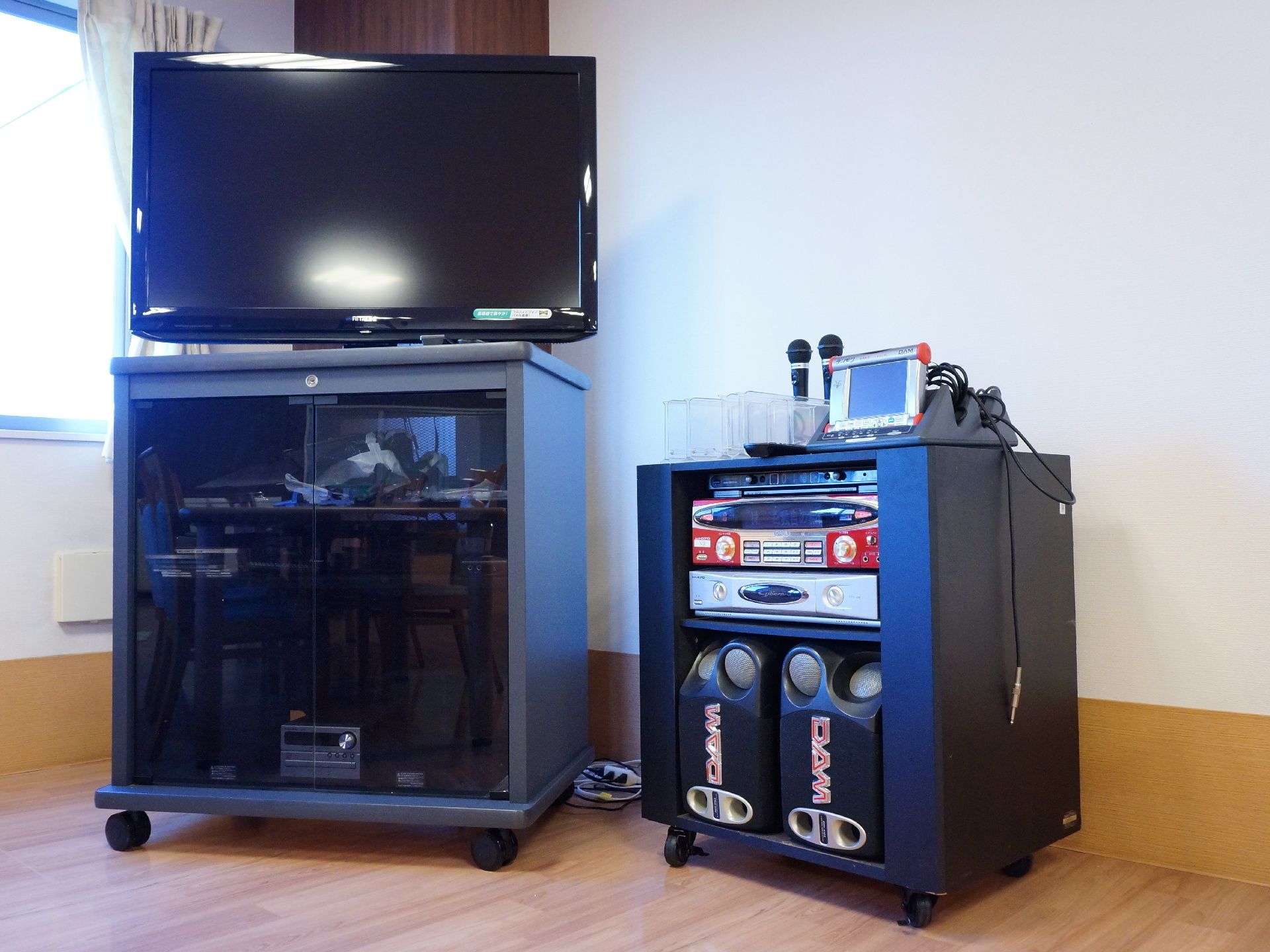 リビングの角にはテレビとデッキ、マイクやスピーカーとカラオケ設備一式が取り揃えられている。通常のテレビ鑑賞のほかカラオケとしても使用できる。