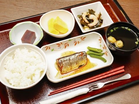 食事は黒いお盆の上にのせて一人ずつ配膳される。この日のメニューはさんまの梅かつお煮で、小鉢のおかずも数品ついており、フォークもついている。