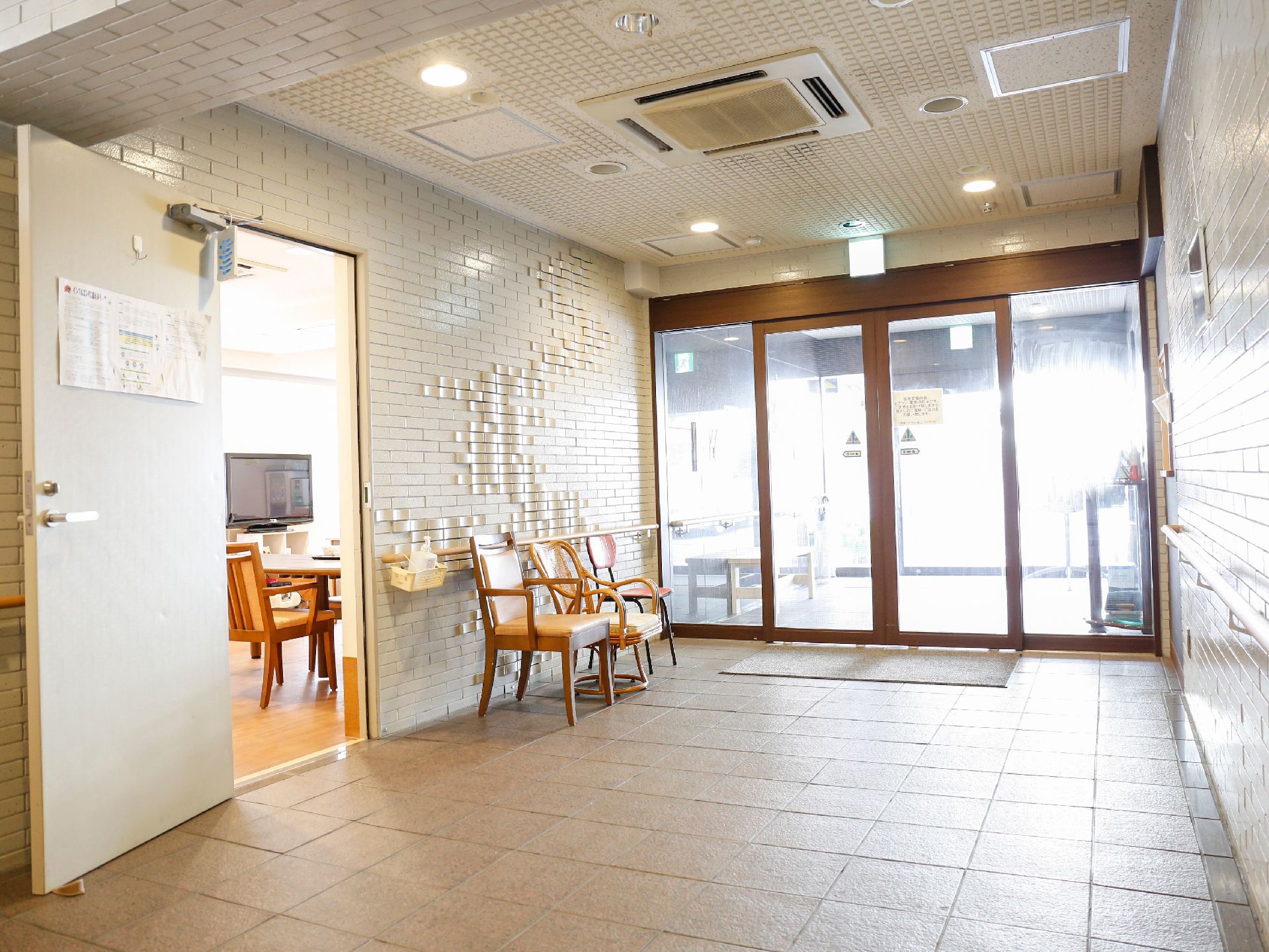 玄関には自動ドアがあり、食堂に入るドアまでは広々としたスペースが広がっている。椅子が置かれているので、休憩することもできる。