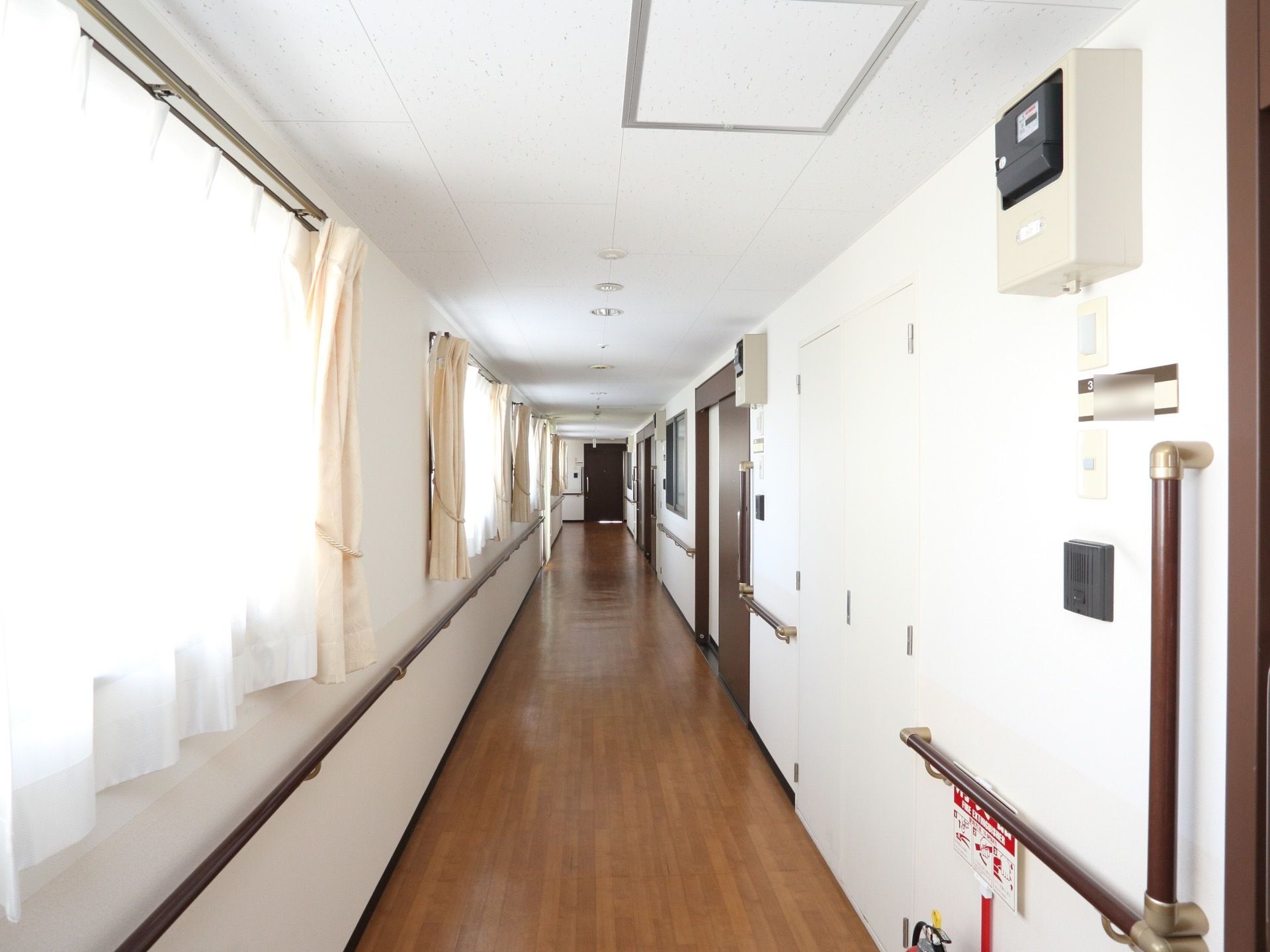 居室が並ぶ反対側に、多数の窓を設置している。窓が多いため、明るい通路である。手すりが両壁に設置されている。