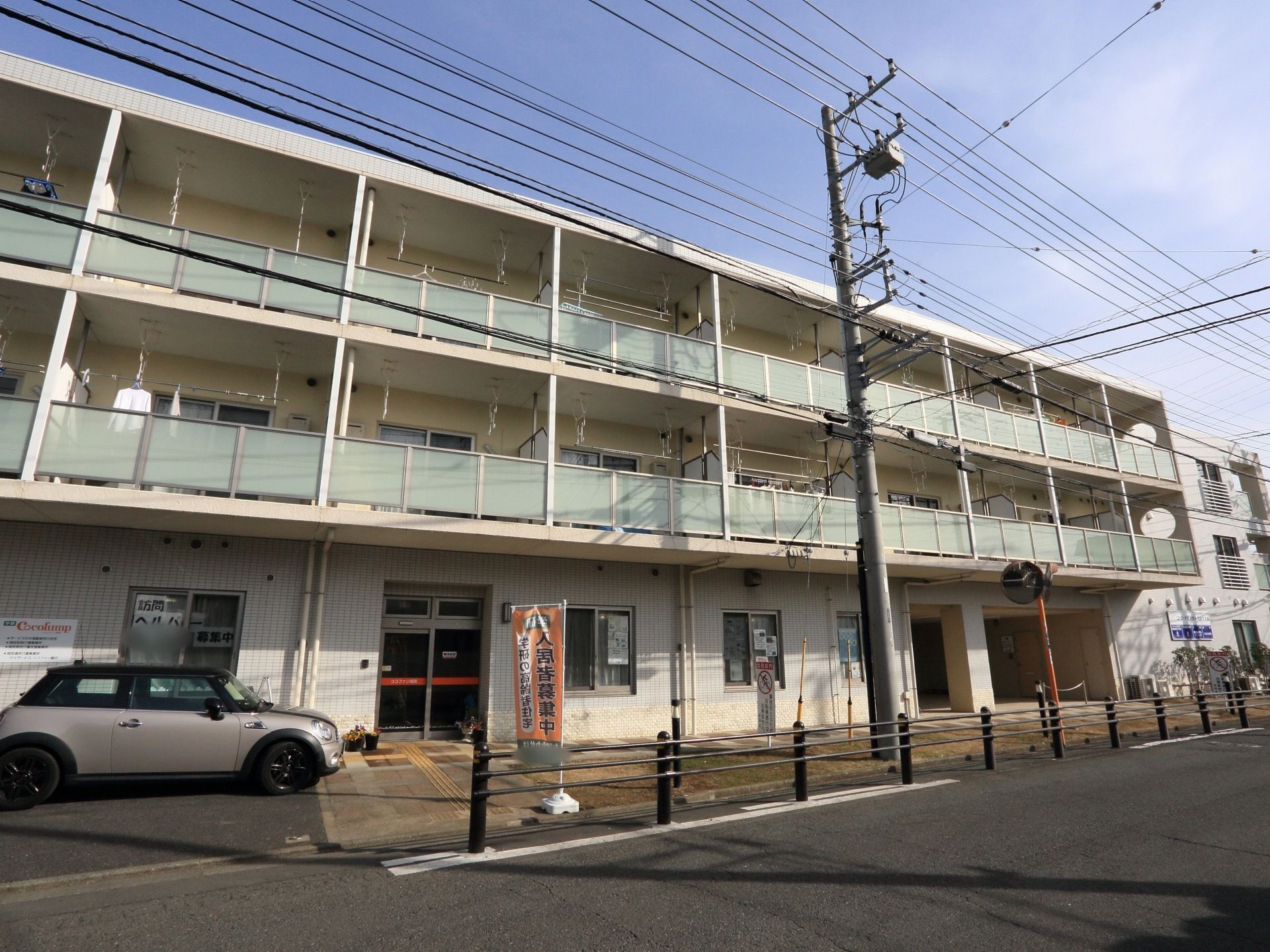 白を基調とした３階建ての建物である。２階より上の階層にはすりガラスの造りのベランダが設置されている。物干しもある。