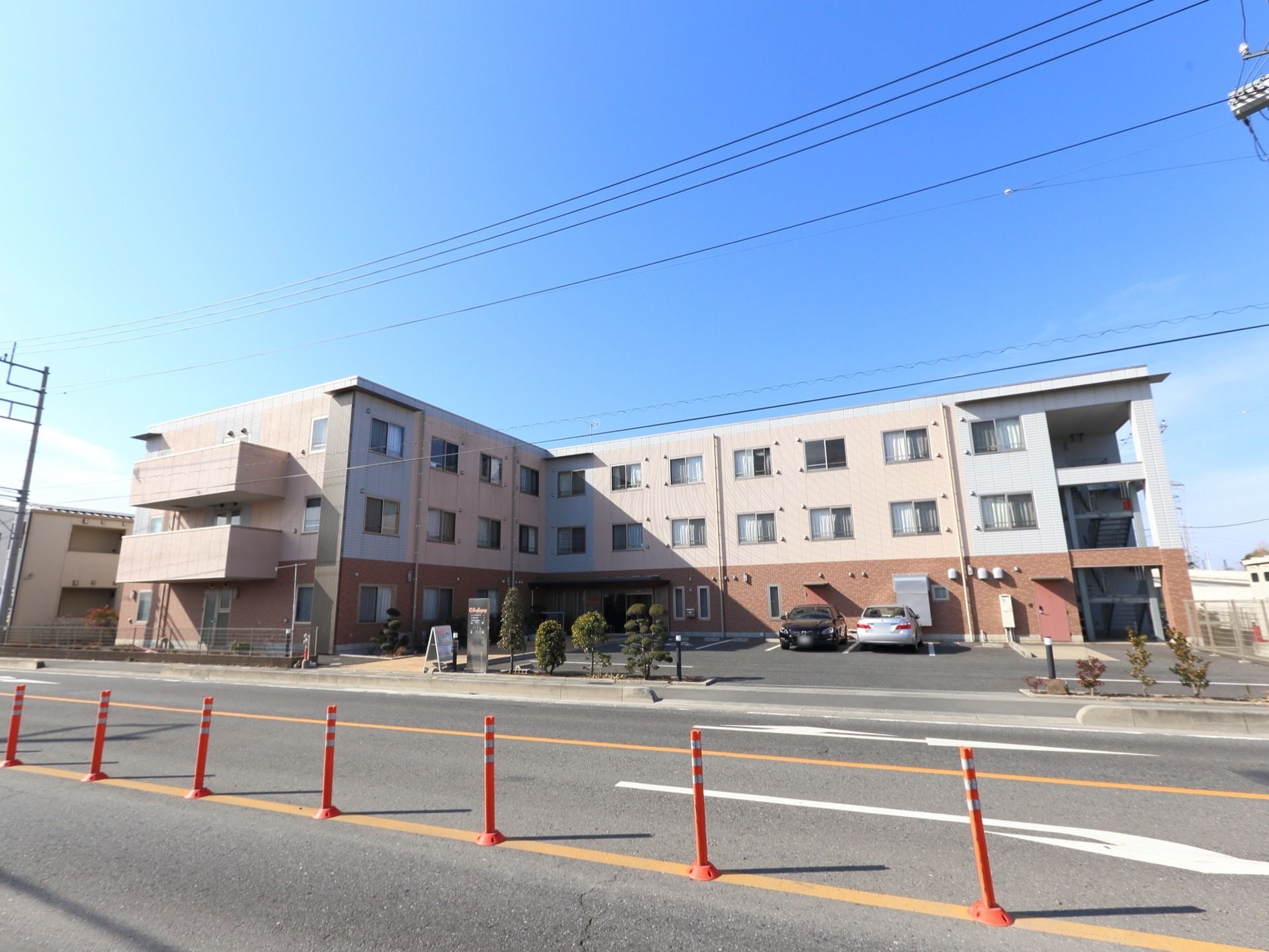 施設は大通りに面した3階建ての大きめな建物である。敷地が広く駐車場も完備している。右手には非常用階段がある。