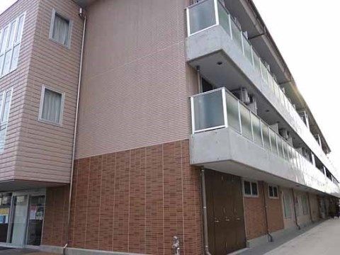 右側にベランダが並び、茶色のレンガが外壁に貼られた建物