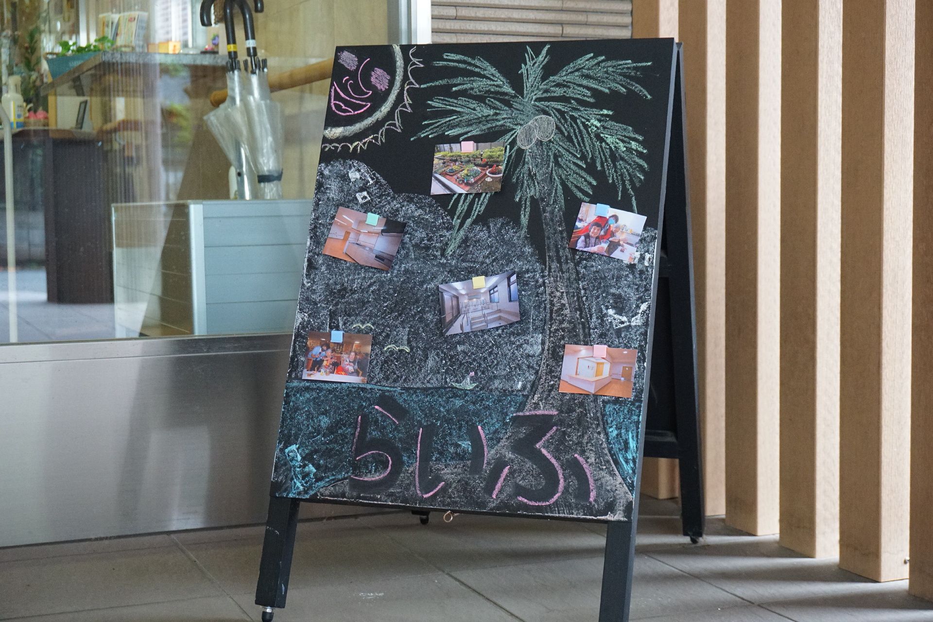 夏にちなんだ絵が描かれ、施設名が記されている黒板の立て看板