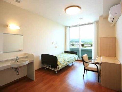 洗面台が完備された、開放感のある居室である。パソコンを使用するのに便利なテーブルと椅子が設置されている。