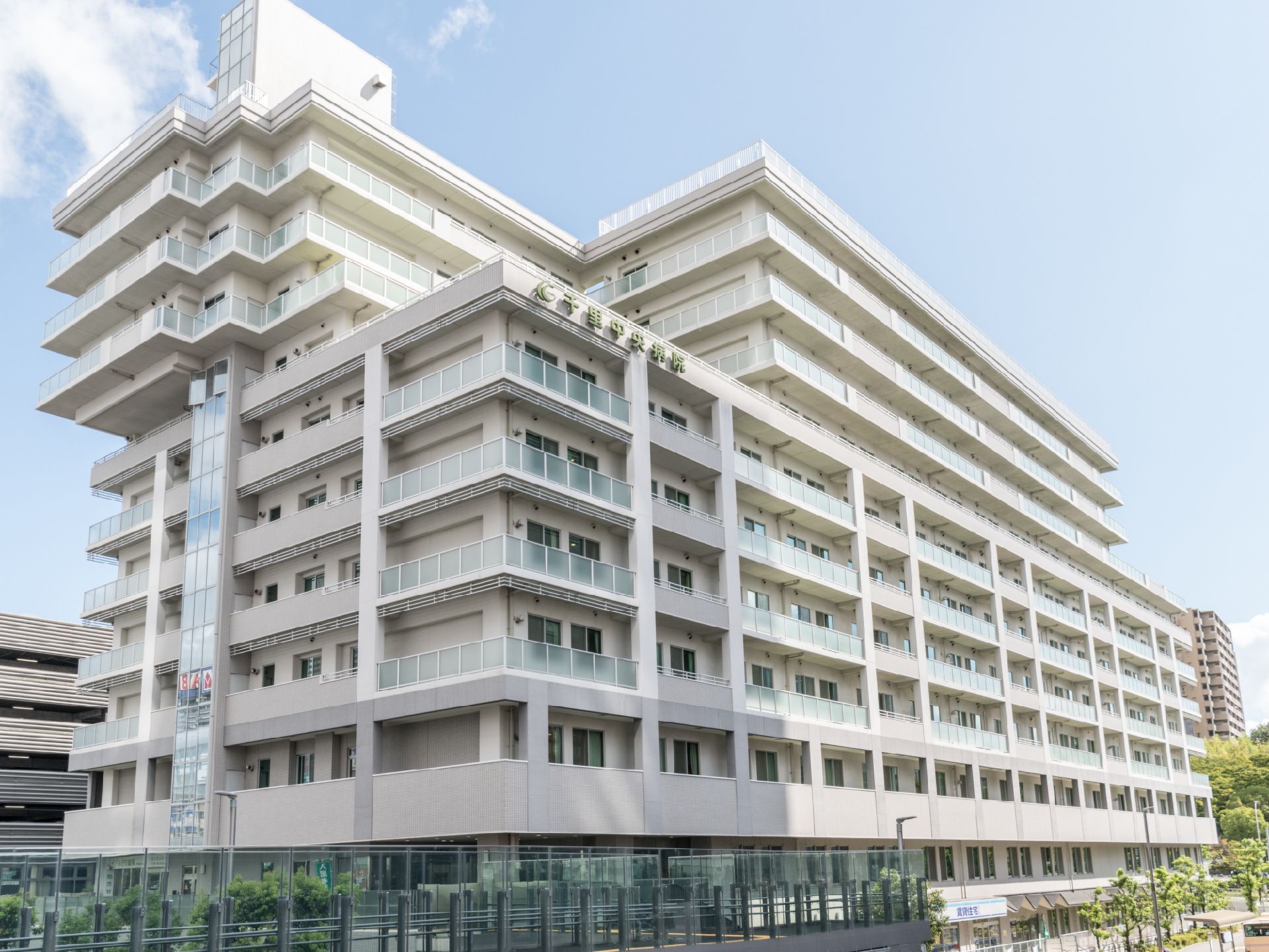 施設は規模の大きい建物で、上部には形の違う階層が設けられている。窓の外にはベランダがあり、上部には施設名が表示されている。