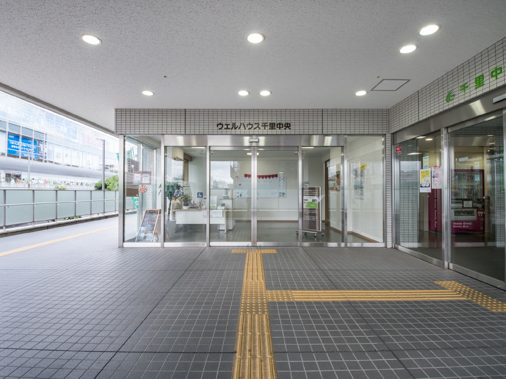 駅前のデッキから続いており、病院の入口と並んでいる施設の玄関