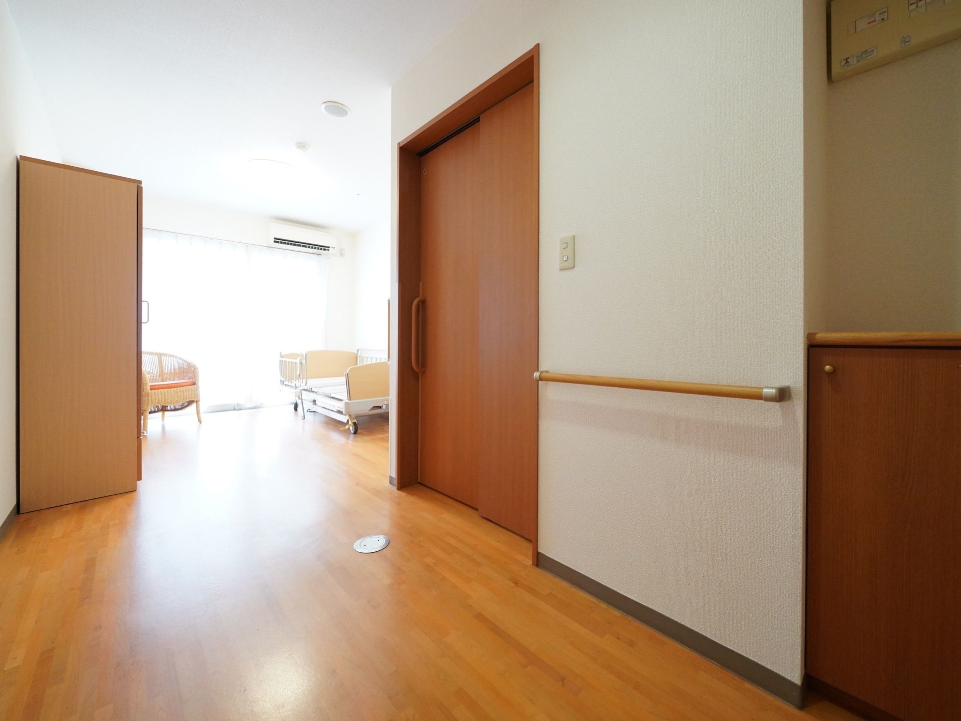 窓から日差しが入り込む温かな居室。ベッド、椅子、エアコン、クローゼット、トイレが室内には揃っている。