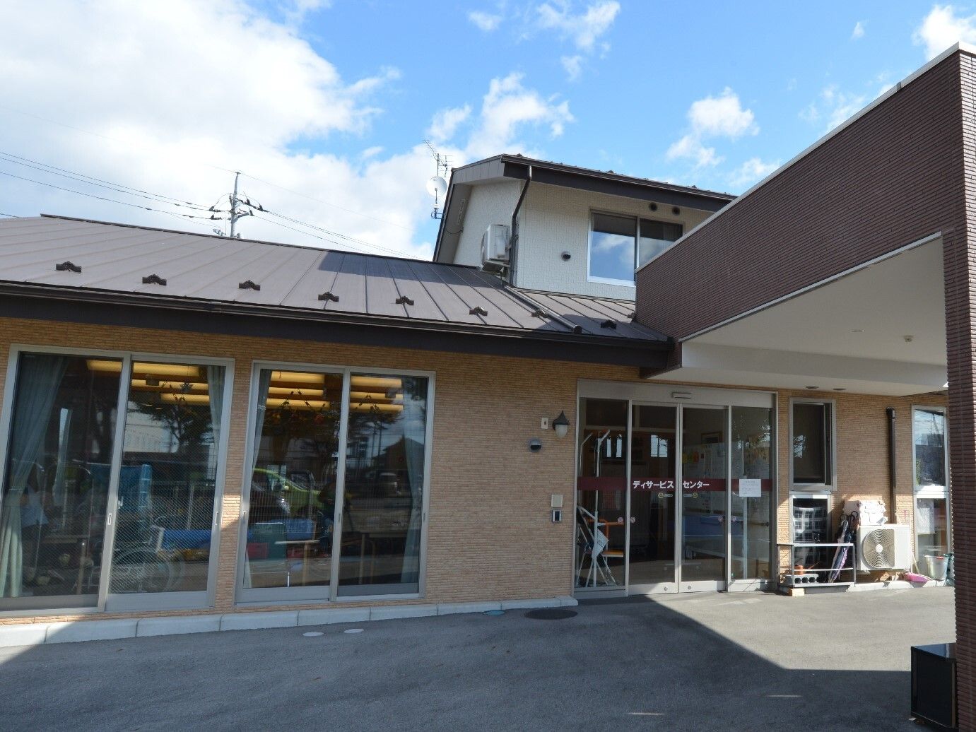 施設ので入り口に車寄せがあるエントランス部分は1階建ての作りになっており、外壁には施設名が記されている。