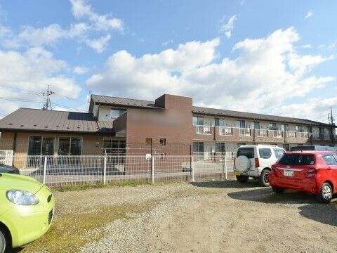 施設建物はエントランス部分が1階建てで、個室のある建物は2階建てになっている。外に広い駐車スペースが設けてある。