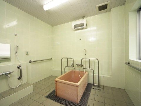 お一人で入浴していただける小さな浴槽は、ヒノキ風呂である。浴槽の両側に手すりがあるので、出入りも楽に行える。上にはヒーターも完備されている。
