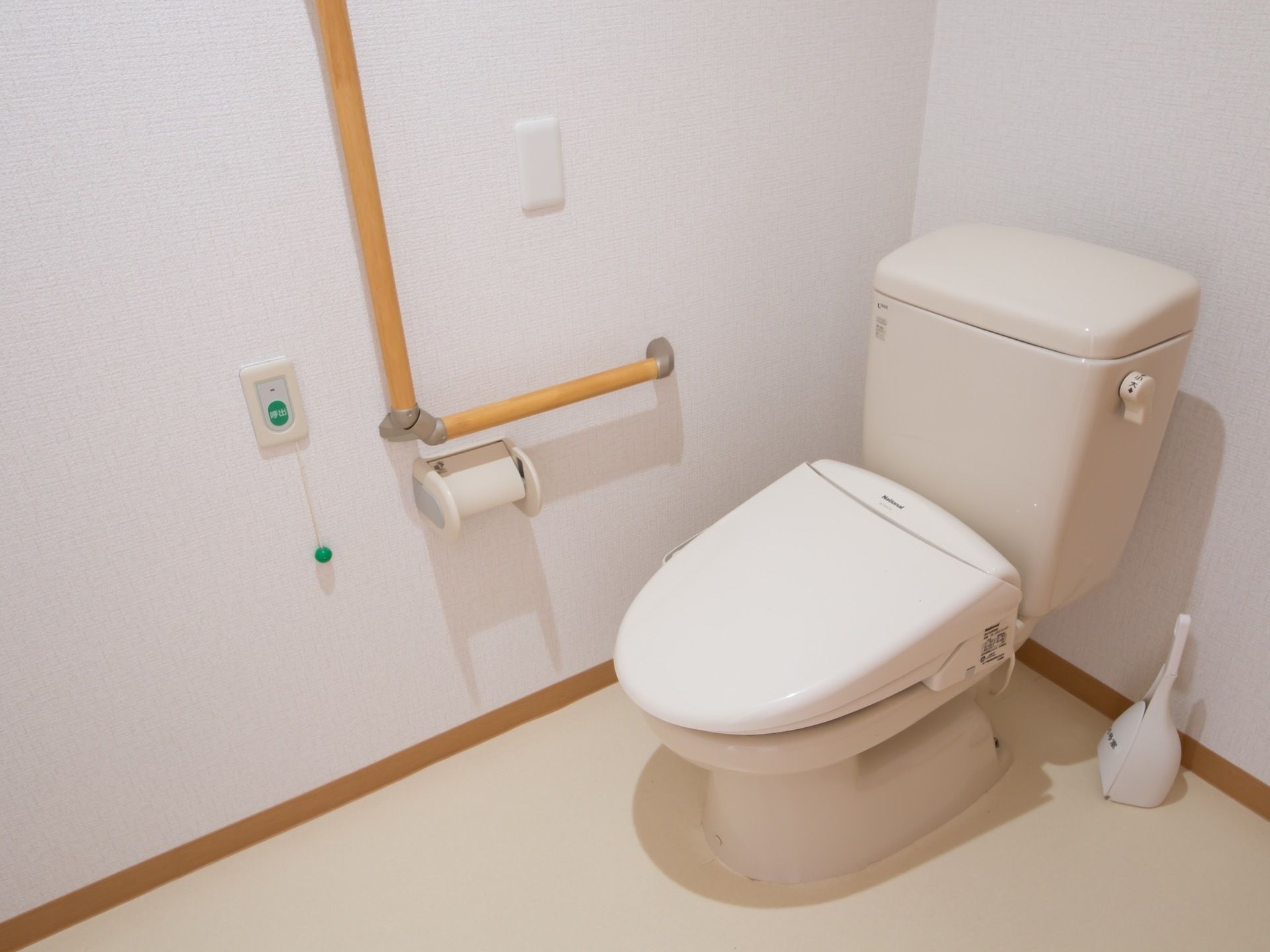 居室のトイレは所動作が行いやすいように、十分な広さを設けている。壁にはナースコールとＬ字型の持ちやすい手すりを取りつけている。