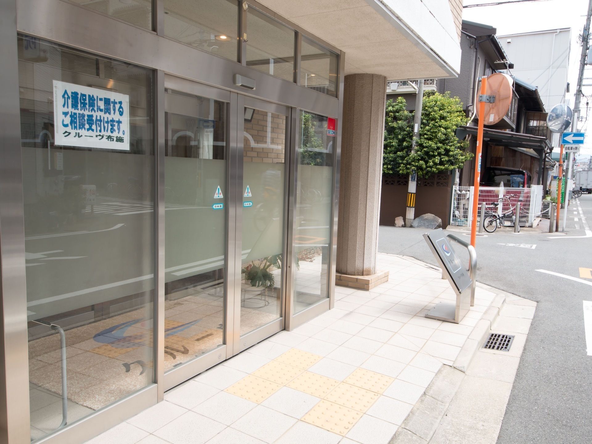 玄関はガラス張りで、部分的にすりガラスが使用されている。ガラスには警備会社のステッカーや相談を受けつけますと書かれた紙が貼られている。