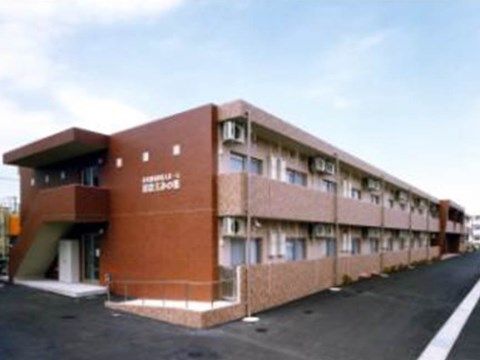 手前に外階段があり、その壁に施設名が書かれている奥に長い建物