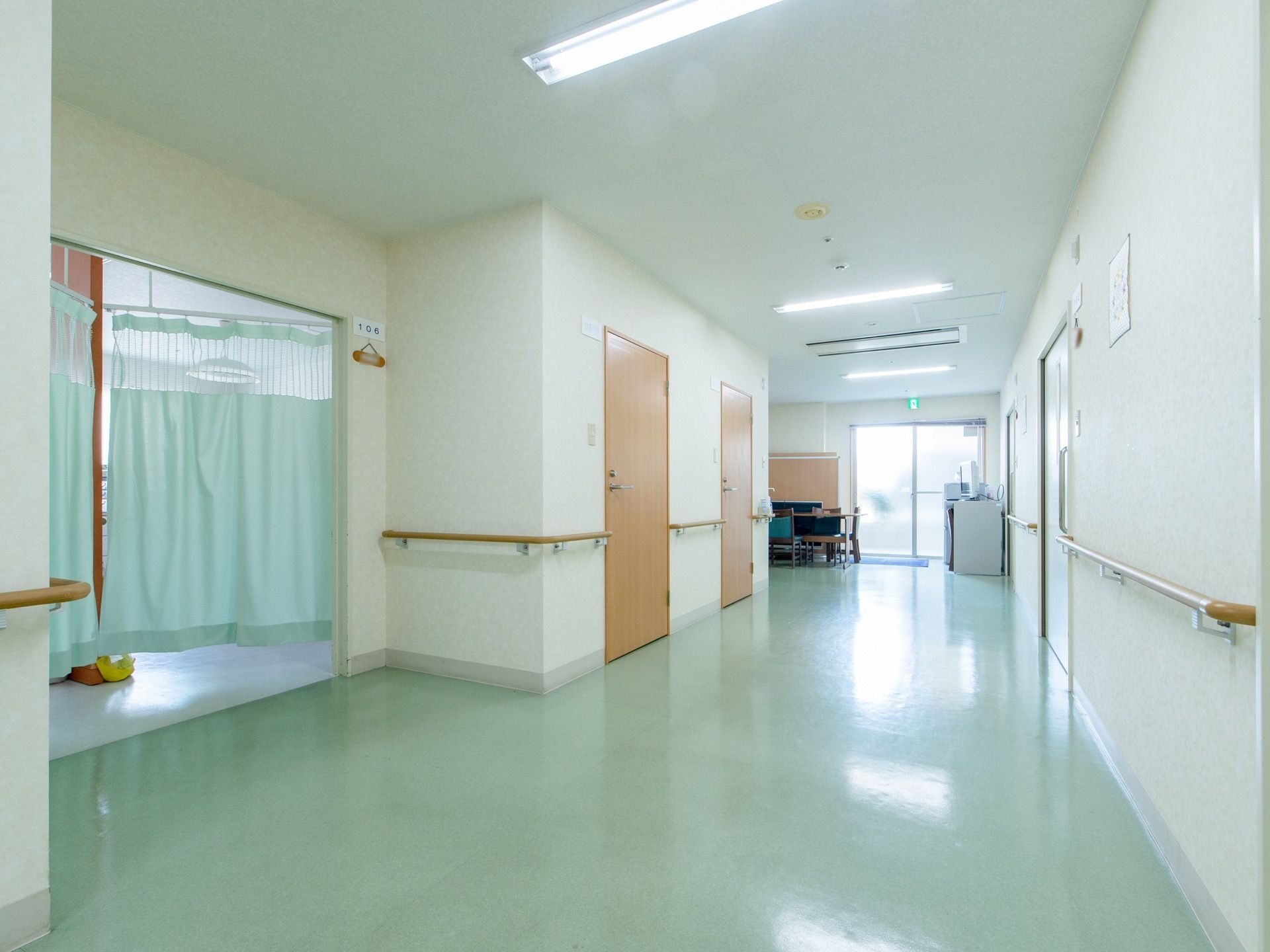 ライトグリーンが鮮やかな廊下である。天井の照明は直管タイプの蛍光灯で、通路に対して直角に取りつけてある。