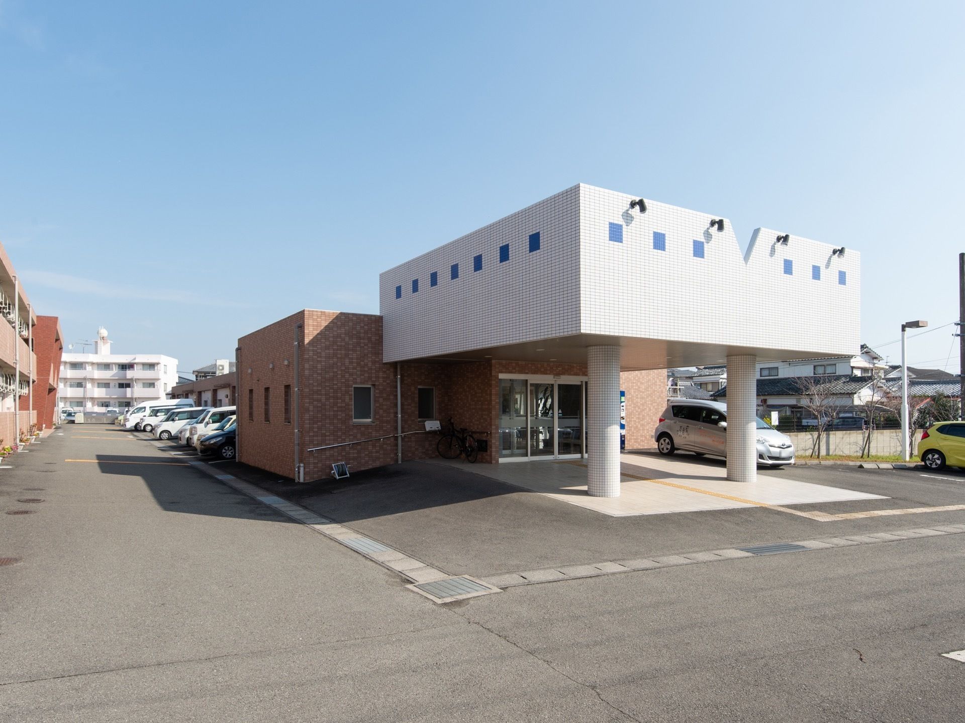 正面玄関には、柱で支えられた大きなひさしがある。その左右には送迎のために自動車を乗りつけられるスペースが設けてある。