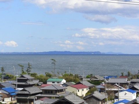 施設の屋上から見る事ができる、住宅街の奥に広がる海