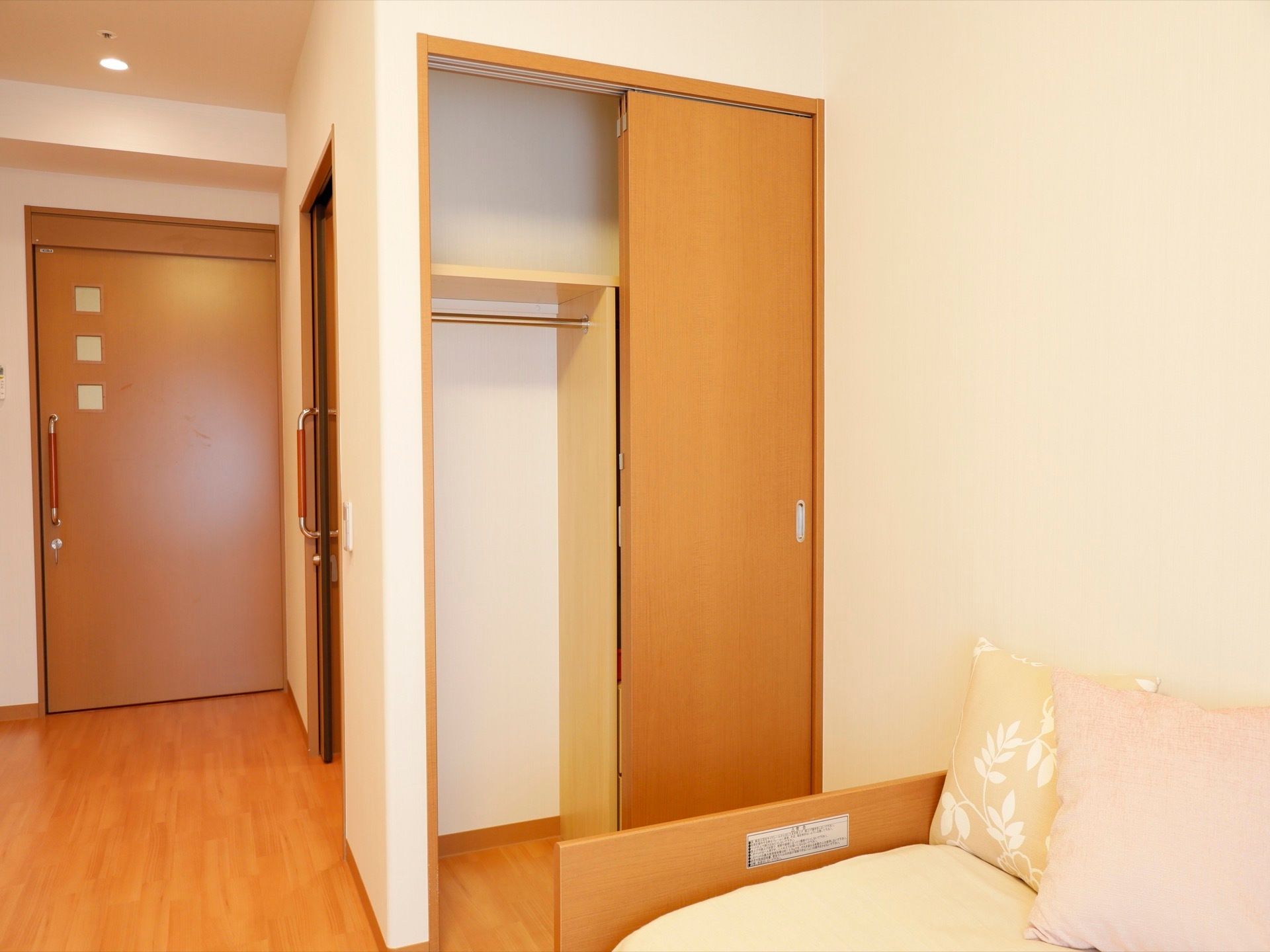 ベッドのそばに、引き戸の収納がある。収納空間が上下２段に仕切られており、下段は左右にも仕切られている。