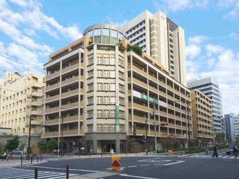 大通の交差点の角地に建つ、高層マンションのような建物