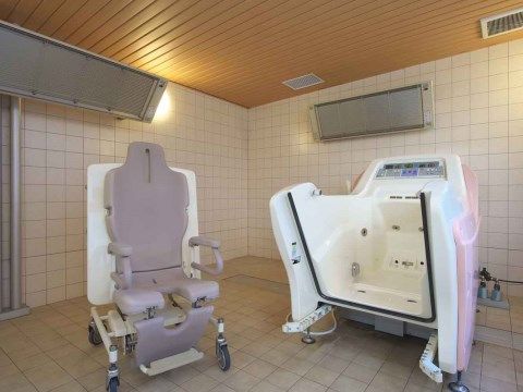 要介護の入居者様用の特殊浴槽が用意されている。広い浴室に座ったまま入浴ができるストレッチャーが置かれている。