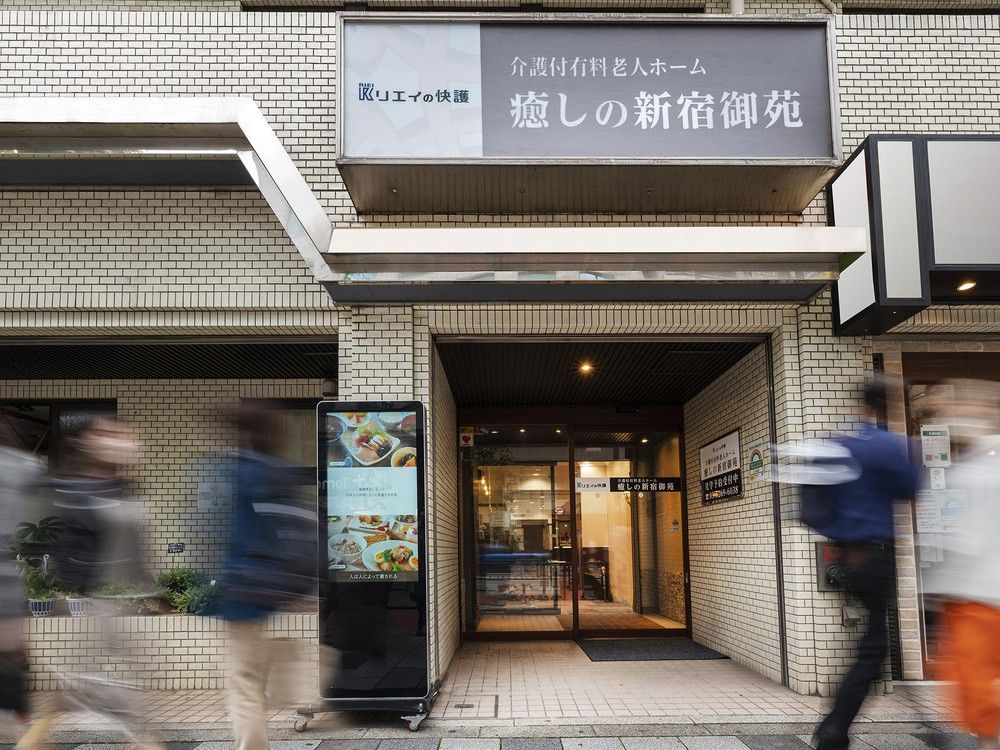 マンションのような外観のグループホームである。２階以上の部分にはベランダが設置されており、入口上の外壁には看板が取り付けられている。