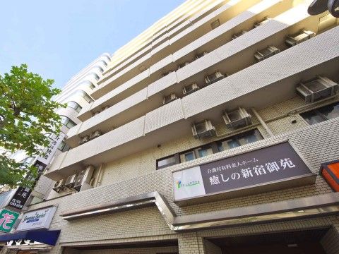 マンションのような外観のグループホームである。２階以上の部分にはベランダが設置されており、入口上の外壁には看板が取り付けられている。