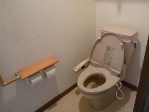 トイレは、白く清潔な空間となっている。移動のサポートとなる手すりを設置しているので、快適にご利用いただける。