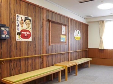 茶色の木目の壁に沿って、畳を敷いたベンチが置かれている。壁には昭和時代のポスターや牛乳ポストが飾られ、昔を懐かしいスペースとなっている。