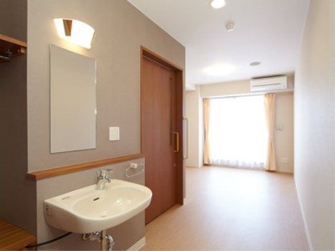 木の温もりが感じられる居室。クローゼットや洗面台、トイレが並んだスペースとリビングスペースはスライド式ドアで間仕切ることができる。