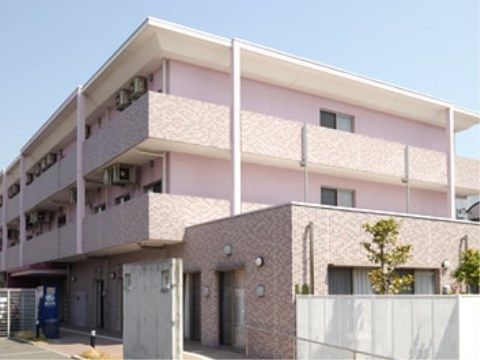 ３階建ての真新しい建物は、一部がタイル張りの淡いピンク色の外観。２，３階部分には建物全体を取り囲むバルコニーがある。