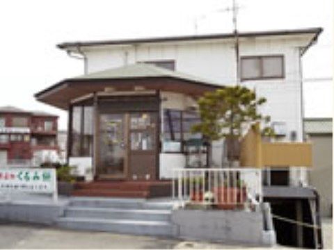 敷地左側のフェンスに幕がある。階段を上がって正面に八角形の建物が付きだしており、周りのプランターに植物が植えられている。
