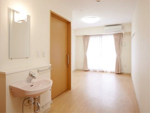 居室はゆったりとしており、洗面台やエアコンが設置されている。緊急時に備えて壁にはナースコールが付いている。