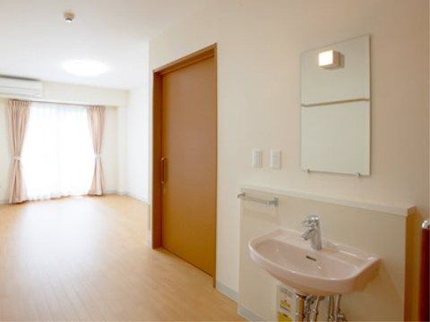 白を基調とした居室で、窓からは明るい日差しが射し込む。トイレ、洗面台も設けられている。十分なスペースがあるため家具も接地できる。