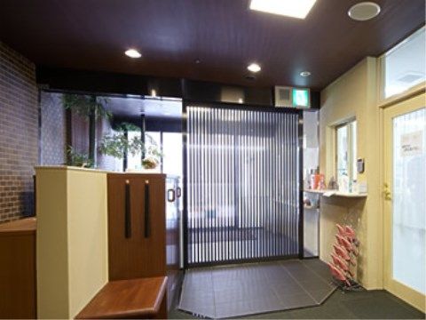 玄関脇の一方の壁はカウンターで、もう一方は靴箱がある。たたきでスリッパに履き替えて、施設に入る流れである。