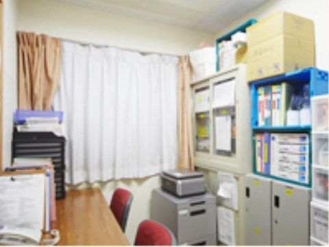 窓がある明るいスペースで、さまざまな書類の管理をしている。入居者様の健康を日々チェックしてサポートを行っている。